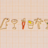 Jewelry gold pendants shaped like dinosaur. palm tree, carrot, tequila shot, martini drink, champagne glass
