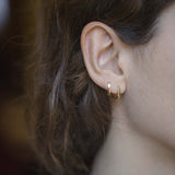 Mini gold hoop earrings worn by model