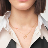 Model wearing gold chain necklace with small dog shaped pendant
