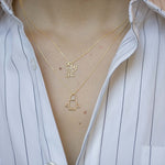 Gold chain necklace with family shaped pendant worn by model