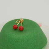 Green sweet pastry with coral cherries gold earring on top